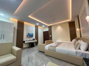 a bedroom with a bed and a couch and a television at Hotel Shanvi Inn in Jabalpur
