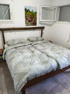 a bed in a bedroom with a white and gray comforter at Villa proche plage pour 3 pers in Vielle-Saint-Girons
