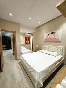 a bedroom with a large white bed in a room at Lost At Sea 2 in Sarandë +6 photos