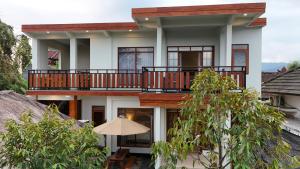 a house with a balcony and a patio at Suci's Friendly Apartments in Mataram
