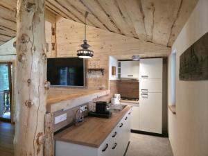a kitchen with a counter and a tv on the wall at Cabana Valea Brândușelor in Bran