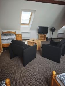 a living room with two chairs and a television at Penzion Moyzes in Banská Bystrica