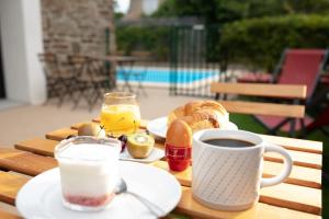 a table with breakfast foods and a cup of coffee at MAISON MIGNARDISE - Cité in Carcassonne
