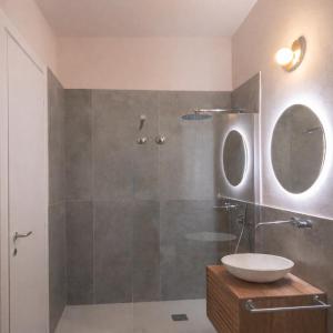 a bathroom with a shower with a sink and a mirror at Eterea Dimora Sul Fiume in Noto