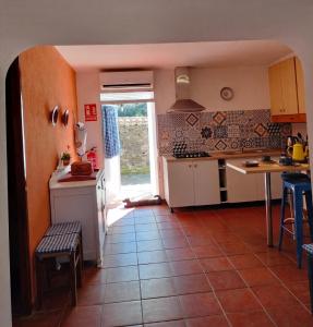 a kitchen with a tile floor and a table with chairs at Casa Celia in Miranda del Rey