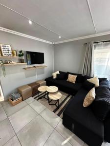 a living room with a black couch and a tv at Klein Escape in Wilderness