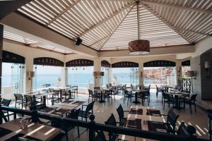 a dining room with tables and chairs and windows at Reef Oasis Beach Aqua Park Resort in Sharm El Sheikh