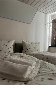 an unmade bed in a bedroom with a window at Stadtvilla Annabelle - mit Sauna in Meschede