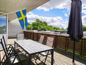a patio table and chairs on a deck with an umbrella at Villan Lyan in Lund