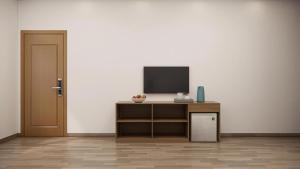 a room with a television on a cabinet and a door at Eco House Cat Ba in Hai Phong +1 photo