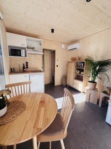 a kitchen and dining room with a wooden table and chairs at Les Deux M Tiny House with Private Garden in Sorgues