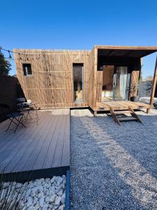 a wooden house with a deck and a table at Les Deux M Tiny House with Private Garden in Sorgues