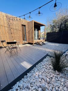 a cabin with a table and chairs on a wooden deck at Les Deux M Tiny House with Private Garden in Sorgues +5 photos