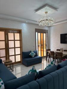 a living room with blue furniture and a chandelier at Tangier Beach Front in Tangier