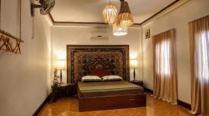 a bedroom with a bed and a chandelier at MI CASA Luang Prabang in Luang Prabang +53 photos