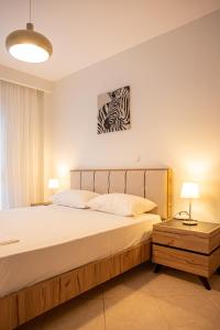 a bedroom with a large bed and two lamps at Theatre Home Aegean View in Nea Moudania