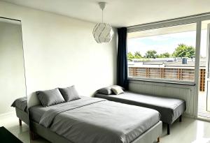 a bedroom with two beds and a large window at Villan Lyan in Lund