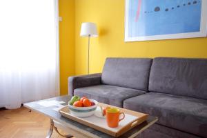 sala de estar con sofá y mesa con un bol de fruta en City Centre Cosy Apartments, en Budapest
