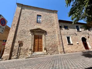 a large brick building with a wooden door at Il Cenerone in Pineto