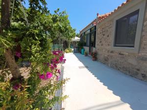 a walkway next to a building with flowers at River Houses Molyvos in Mythimna