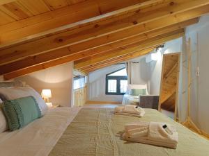 a bedroom with a large bed with wooden ceilings at River Houses Molyvos in Mythimna