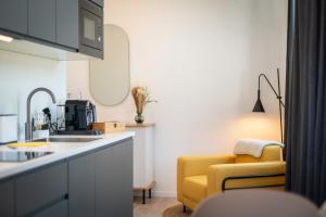 a kitchen with a yellow chair and a kitchen counter at nestup - Hildesheim Zentral in Hildesheim