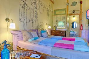 a bedroom with a large bed with a painting on the wall at Lavender Circus Hostel, Doubles & Ensuites in Budapest