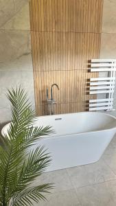 a white bath tub in a bathroom with a plant at Stodoła przy deptaku in Ujsoły +8 photos