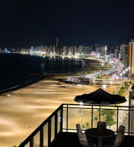 a view of a beach at night from a balcony at Atlantic Ocean Residence in Fortaleza