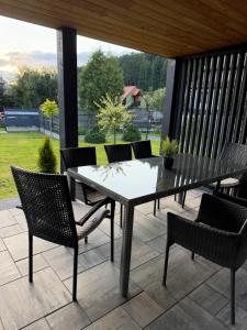 a dining table and chairs on a patio with a view at Stodoła przy deptaku in Ujsoły