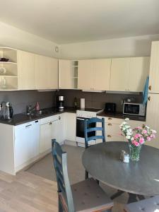 a kitchen with a table and a kitchen with white cabinets at Happy house katajanokka in Helsinki