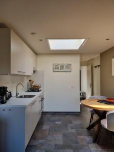 a kitchen with a sink and a table with a tablektop at Mooi zo 2 in De Koog