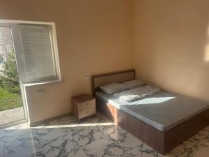 a bedroom with a bed and a window at Garden Guesthouse in Yerevan