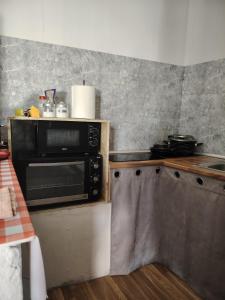 a kitchen with a stove and a microwave at Casa adosada con patio in Jerez +4 photos