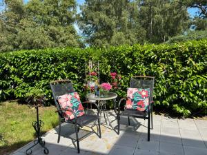 ein Tisch mit zwei Stühlen und ein Tisch mit Blumen in der Unterkunft Kullsbacka in Skanör med Falsterbo + 31 Fotos
