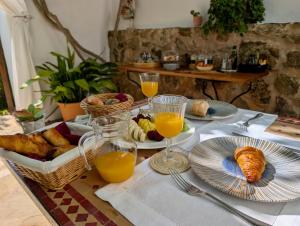 a table with a breakfast of bread and orange juice at Can Pardal in Sant Miquel de Balansat