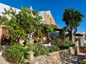a house with trees and plants in front of it at Can Pardal in Sant Miquel de Balansat
