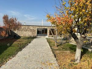 a stone path in front of a building with a tree at Garden Guesthouse in Yerevan