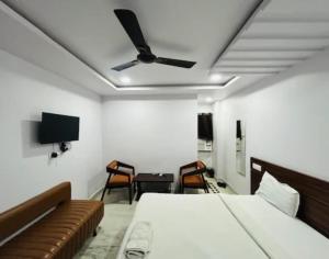 a bedroom with a bed and a ceiling fan at hotel darbar international in Gaya