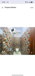 a bathroom with a toilet and a brick wall at hotel darbar international in Gaya +41 photos