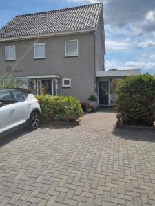a white car parked in front of a house at Mooi zo 2 in De Koog