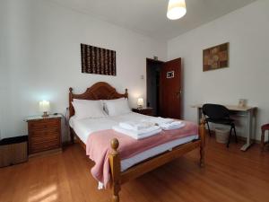 a bedroom with a bed with a desk and a desk at Casa Os Maias - Jardim, terraço e espaço para 10 pessoas in Mirandela