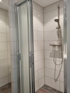 a shower with a glass door in a bathroom at Mooi zo 2 in De Koog
