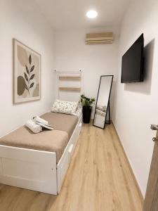 a bedroom with a bed and a flat screen tv at Oasis Pool Flat-near 2 metro stations- in Piraeus