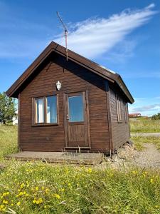 a small wooden house in a field of flowers at Egilsstaðir 1, Sjónarhóll, Urridafossvegur, Selfoss in Selfoss