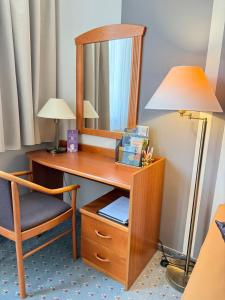 a wooden desk with a mirror and a chair at BeWell Apartment in Zalakaros +45 photos