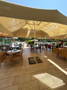 a patio with tables and chairs and an umbrella at BeWell Apartment in Zalakaros