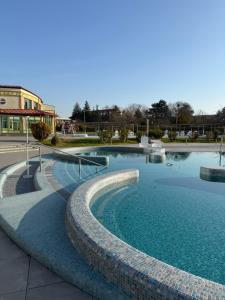 a swimming pool with blue water in a park at BeWell Apartment in Zalakaros