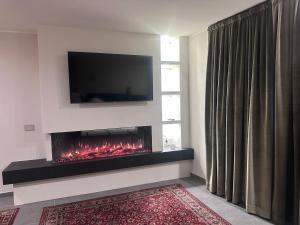 a living room with a fireplace with a tv above it at Casa Delfina in Grosotto