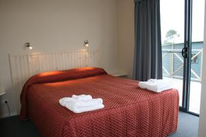 a hotel room with a bed with towels on it at Scamander Tourist Park in Scamander